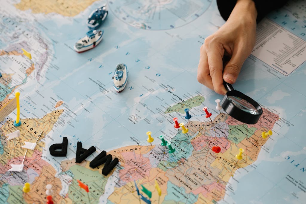 Person Looking at Paper Map with Magnifier, cheap flights airline tickets plane tickets cheap airline tickets book flights cheap plane tickets airtickets fly tickets cheap airfare flight deals